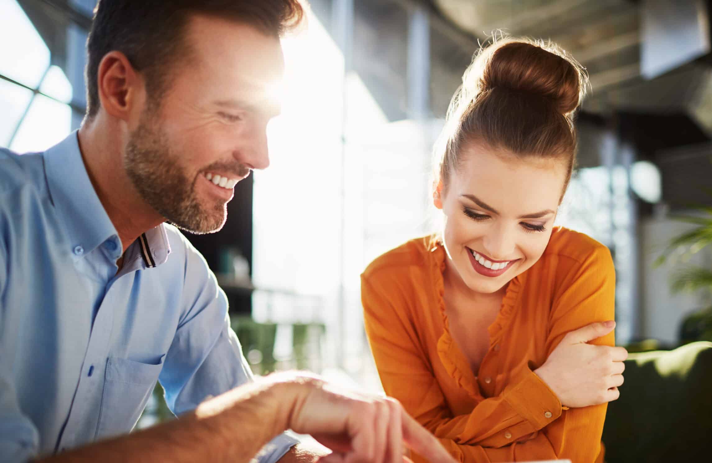 Young couple in modern cafe looking at smartphone