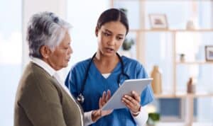 Young nurse helps elderly patient review information